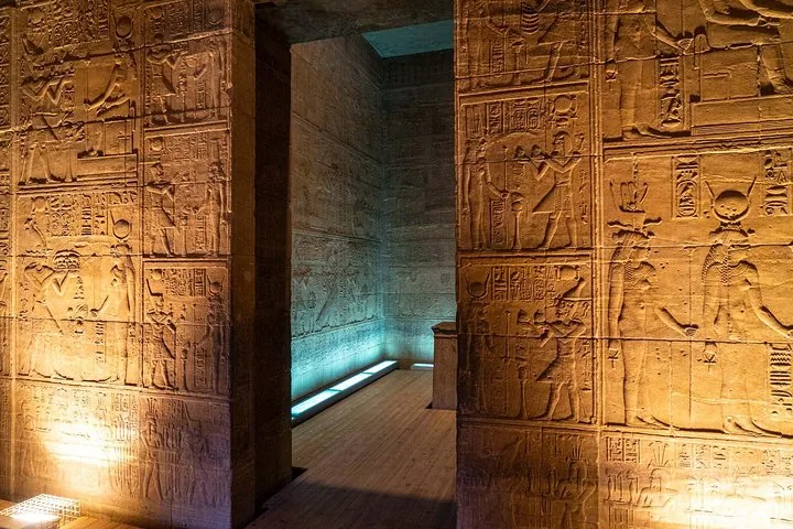Innenwände eines antiken Tempels, beleuchtet, um die kunstvollen ägyptischen Hieroglyphenreliefs hervorzuheben.