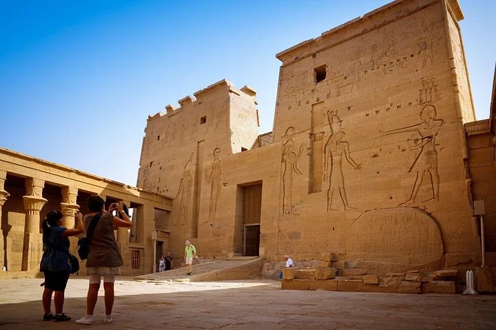Touristen stehen im Hof des Philae-Tempels und fotografieren die kunstvollen Gravuren